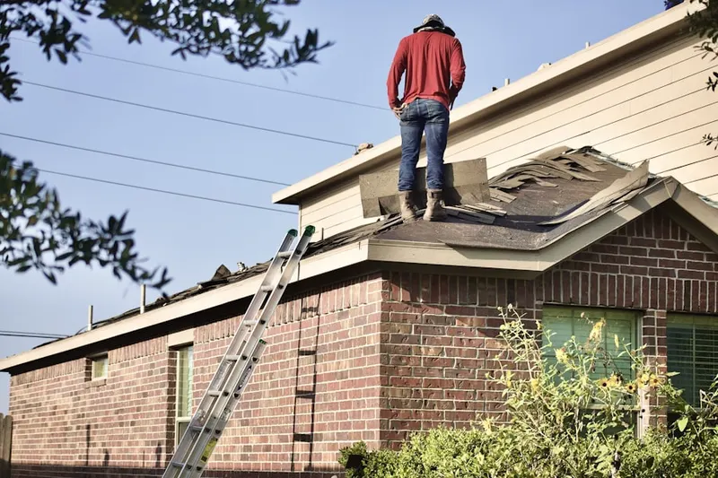 Professional roofer working on a residential roof in Sandy Woods